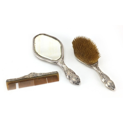 2410 - Victorian silver three piece dressing table set, including hand mirror, embossed with continental fi... 