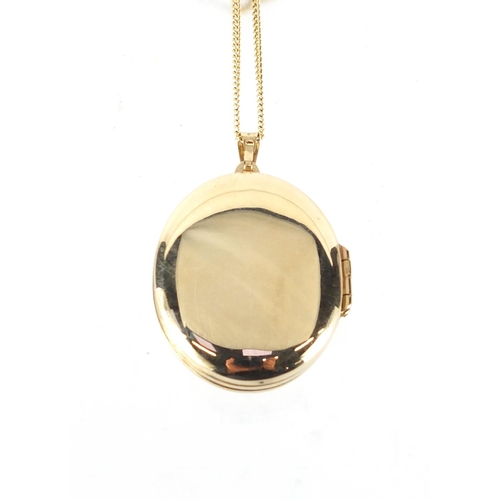 2431 - Oval 9ct gold locket with floral chased decoration, on a 9ct gold necklace, the locket 4.5cm in leng... 