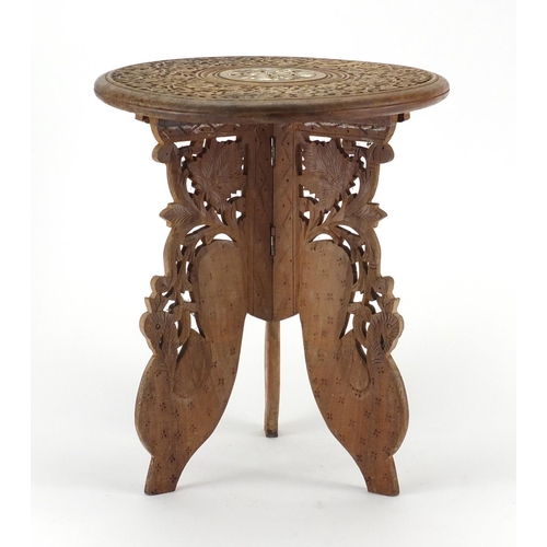 42 - Indonesian carved folding occasional table, with bone inlay, 35cm high x 30cm in diameter