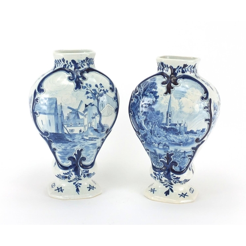 2078 - Two Delft pottery vases, hand painted with a windmill and church, the largest 27cm high