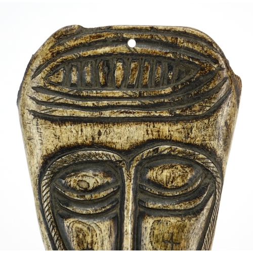 382 - Antique tribal interest bone apron carved in the form of a head, possibly Napalese, 18cm x 13cm