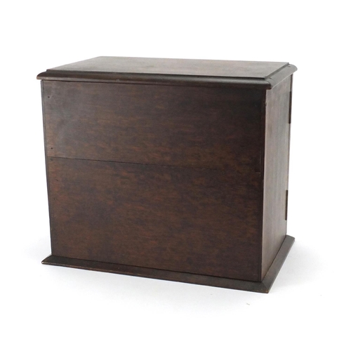 2101 - Oak smokers cabinet opening to reveal two drawers and a revolving pipe rack, 30cm H x 34.4cm W x 21c... 