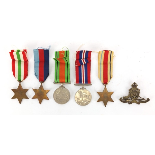 618 - Four British Military World War II medals and a Royal artillery cap badge