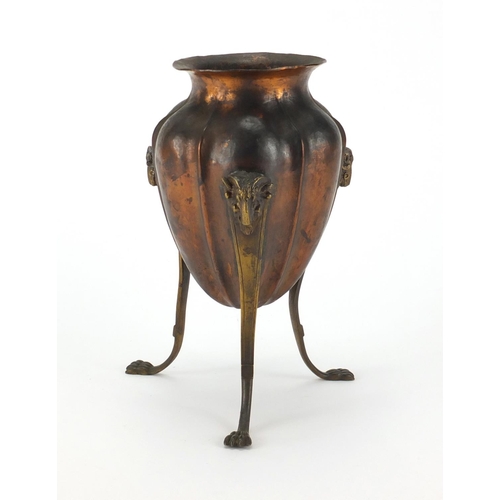 91 - Arts & Crafts copper and brass three footed vase, with rams head mounts, 20cm high