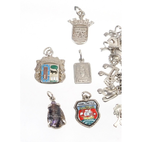 2352 - Silver charm bracelet with large selection of charms including enamelled shields and a silver ring, ... 