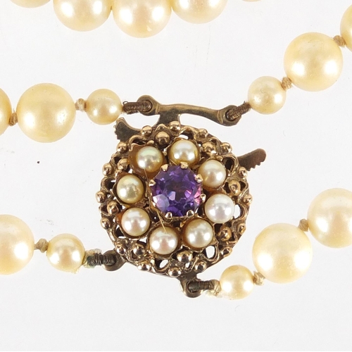 2335 - Simulated pearl two string necklace, with 9ct gold amethyst clasp, 44cm in length, approximate weigh... 