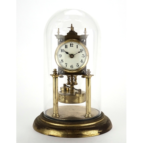 2100 - German brass Anniversary clock with glass dome, the enamelled dial with Arabic numerals, 30cm high