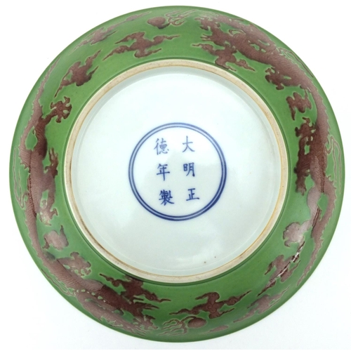 280 - Chinese green ground porcelain dish, hand painted with three dragons amongst clouds chasing the flam... 