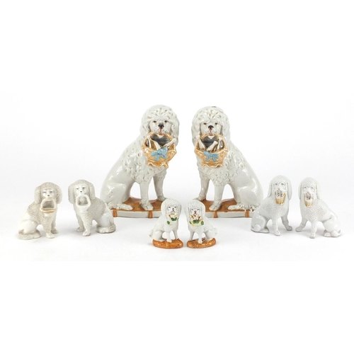 376 - Four pairs of German porcelain Staffordshire style seated dogs, the largest 17cm high