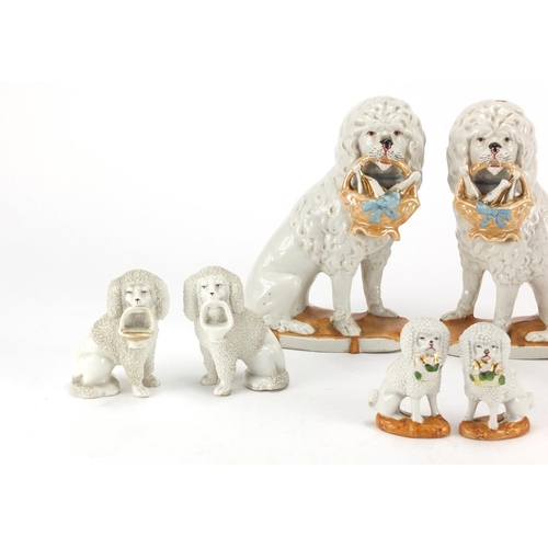 376 - Four pairs of German porcelain Staffordshire style seated dogs, the largest 17cm high