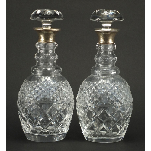 2147 - Pair of cut glass decanters with silver collars, indistinct London hallmarks, each 29.5cm high