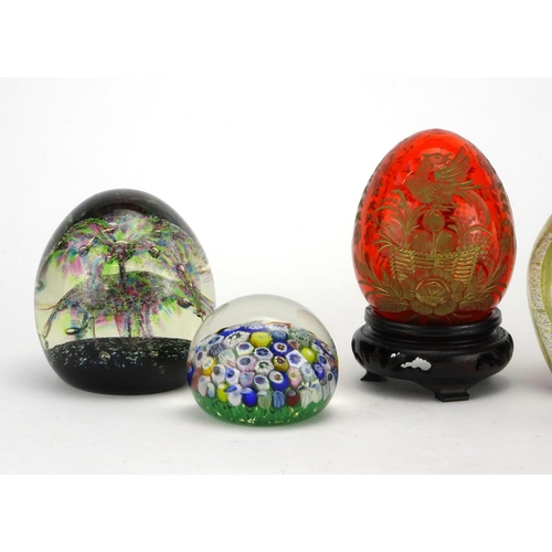 2380 - Five colourful glass paperweights and a Faberge style egg etched with a bird on hardwood stands, inc... 