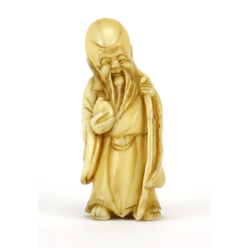 354 - Japanese carved ivory Netsuke of an elder holding a staff and fruit, 5cm high