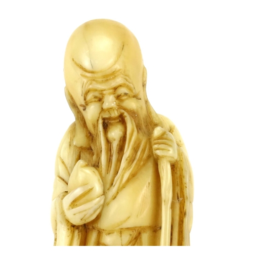 354 - Japanese carved ivory Netsuke of an elder holding a staff and fruit, 5cm high