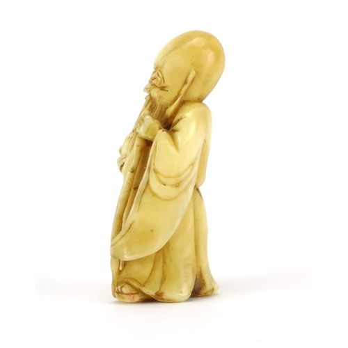 354 - Japanese carved ivory Netsuke of an elder holding a staff and fruit, 5cm high