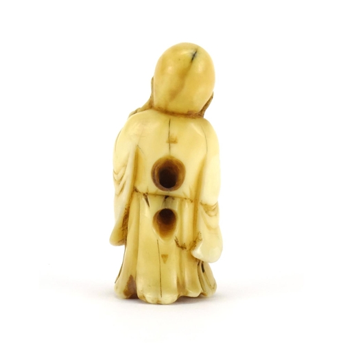 354 - Japanese carved ivory Netsuke of an elder holding a staff and fruit, 5cm high