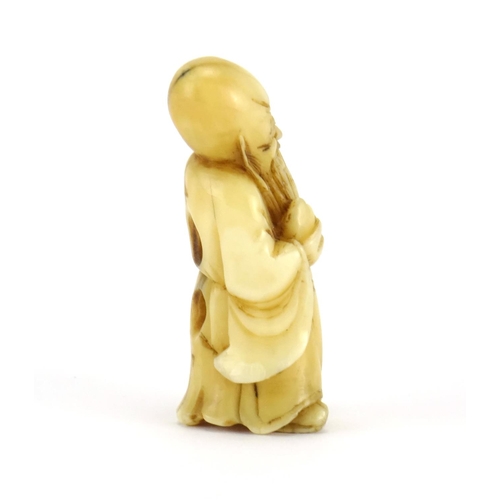 354 - Japanese carved ivory Netsuke of an elder holding a staff and fruit, 5cm high