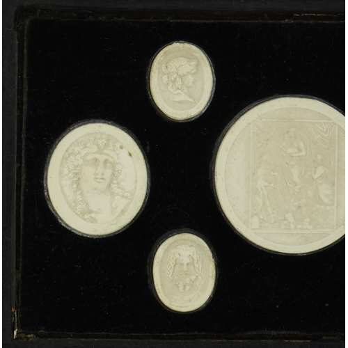 37 - Seven 19th century Grand Tour plaster plaques including six portraits, housed in a hanging display, ... 