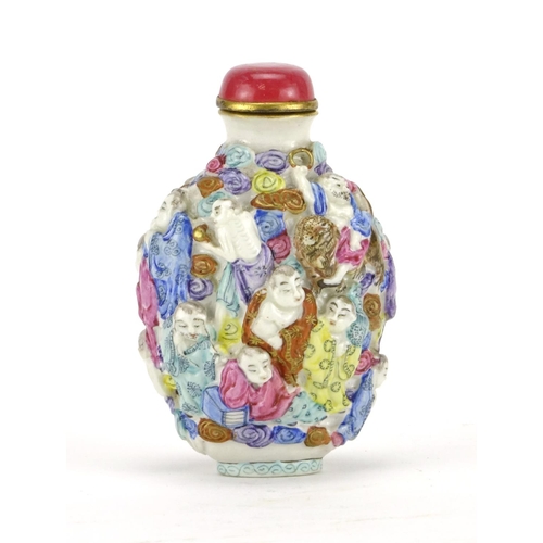 293 - Chinese porcelain relief snuff bottle hand painted in the famille rose palette with figures, four fi... 