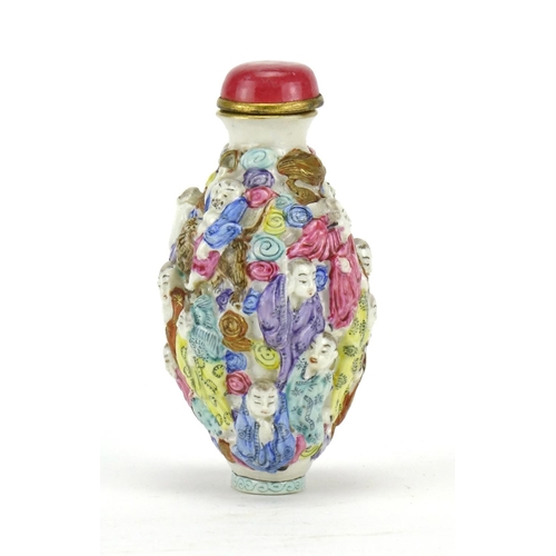 293 - Chinese porcelain relief snuff bottle hand painted in the famille rose palette with figures, four fi... 