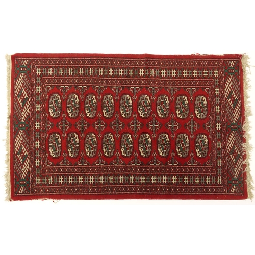 23 - Eastern rug with all over geometric pattern onto a red ground, 123cm x 78cm