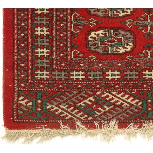 23 - Eastern rug with all over geometric pattern onto a red ground, 123cm x 78cm