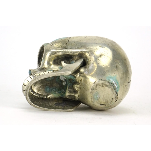 2507 - Silvered metal skull with articulated jaw, 12.5cm in length