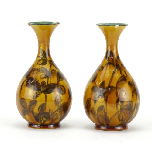 503 - Pair of Linthorpe pottery vases, hand painted with stylised flowers in the style of Christopher Dres... 