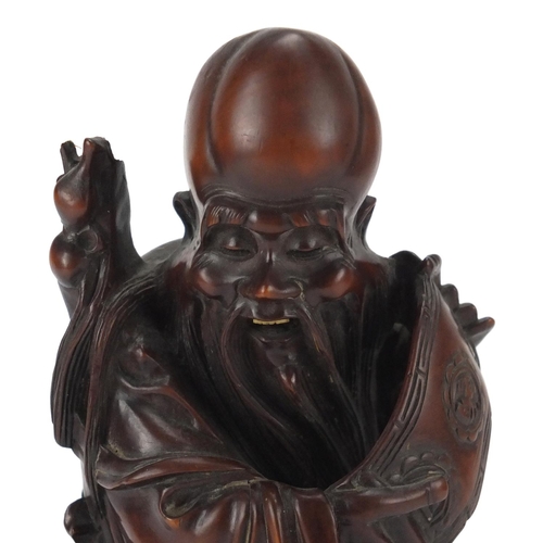 359 - Good Chinese root carving of an elder holding a scroll, raised on a carved hardwood stand, overall 2... 