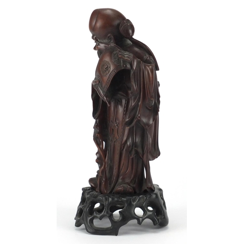 359 - Good Chinese root carving of an elder holding a scroll, raised on a carved hardwood stand, overall 2... 