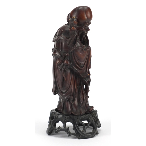 359 - Good Chinese root carving of an elder holding a scroll, raised on a carved hardwood stand, overall 2... 