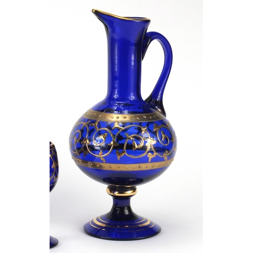 2390 - Venetian blue glass jug and four glasses, each gilded with foliate scrolls, the carafe 28cm high