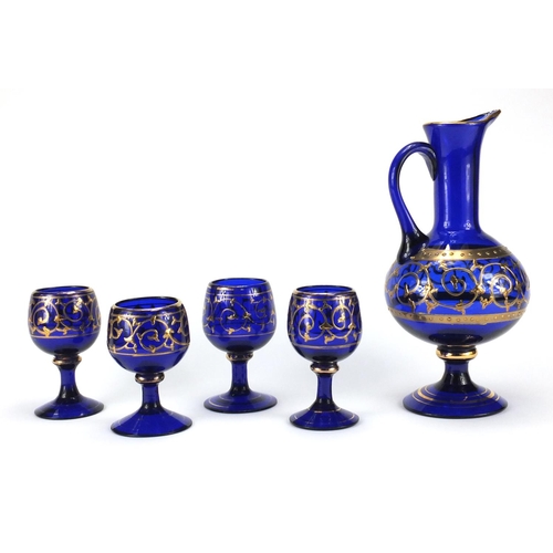 2390 - Venetian blue glass jug and four glasses, each gilded with foliate scrolls, the carafe 28cm high