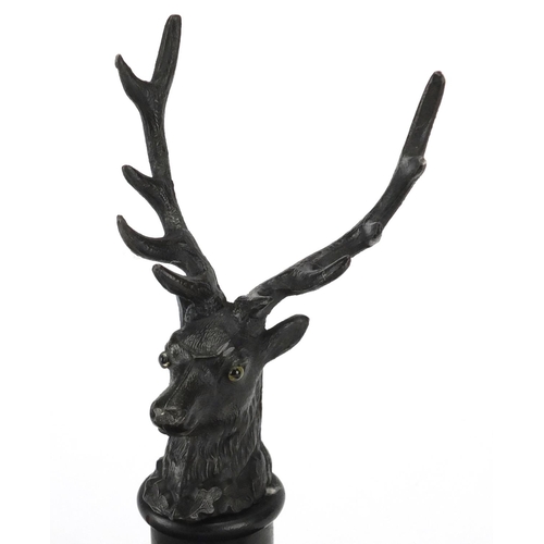 2201 - Ebonised stags head design desk stand, fitted with a pair of glass inkwells, 27cm wide