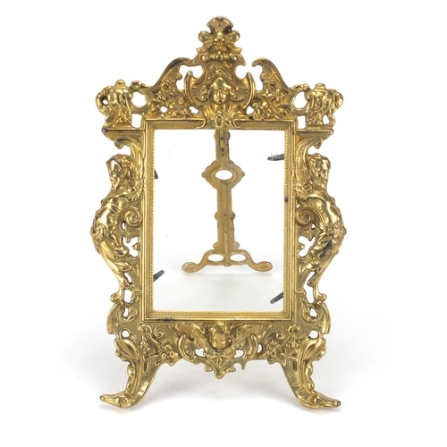 2305 - Ornate gilt brass easel photo frame, cast in relief with mermen, 28cm high