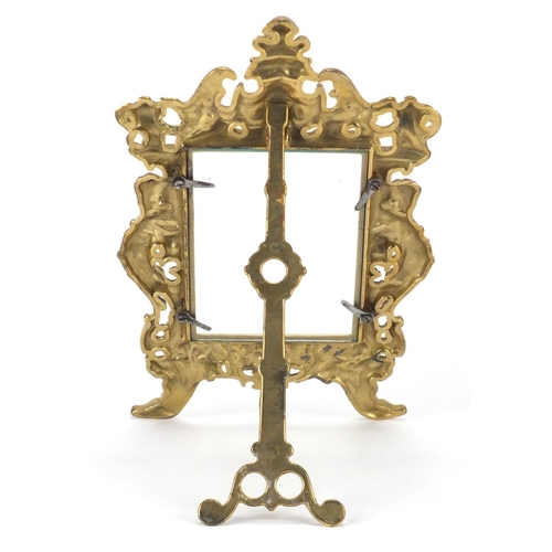 2305 - Ornate gilt brass easel photo frame, cast in relief with mermen, 28cm high