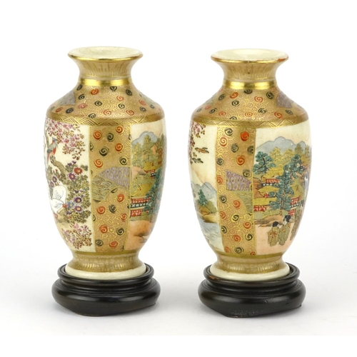 313 - Pair of Japanese Satsuma pottery vases raised on hardwood stands, hand painted with figures, flowers... 