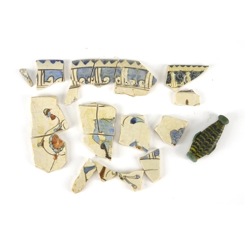 389 - Group of antique Islamic pottery fragments and a glass scent bottle, the scent bottle 4.6cm high