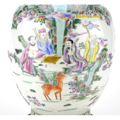 297 - Chinese porcelain baluster vase raised on a hardwood stand, finely hand painted in the famille rose ... 
