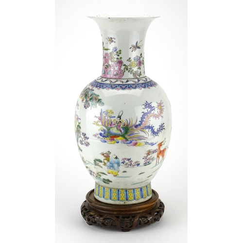 297 - Chinese porcelain baluster vase raised on a hardwood stand, finely hand painted in the famille rose ... 