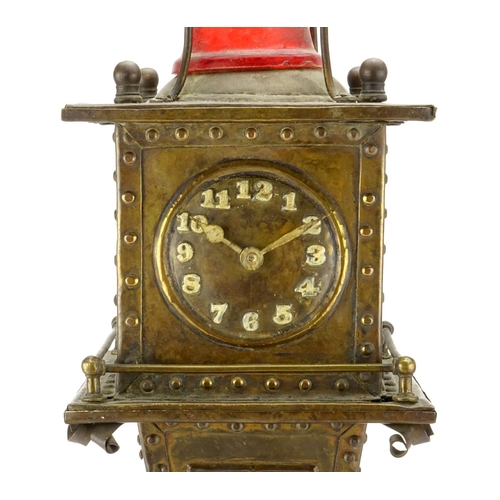 567A - Unusual Arts & Crafts style brass clock in the form of a lighthouse, with Arabic numerals, 53cm high