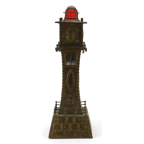 567A - Unusual Arts & Crafts style brass clock in the form of a lighthouse, with Arabic numerals, 53cm high