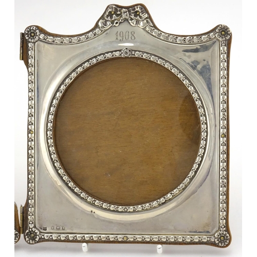 588 - Silver folding double photo frame, embossed with bows and rosettes, by Charles S Green & Co Ltd, Bir... 