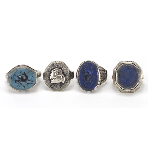242 - Four Islamic silver coloured metal rings, some set with Lapis Lazuli, approximate weight 36.2g