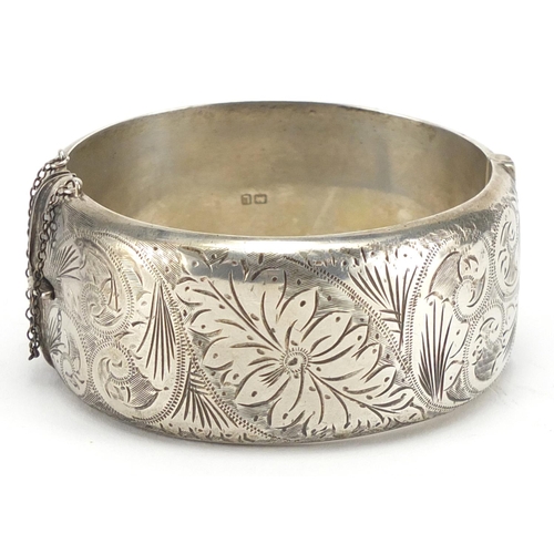 218 - Victorian style silver bangle with floral chased decoration, hallmarked Chester 1961, 7cm in diamete... 