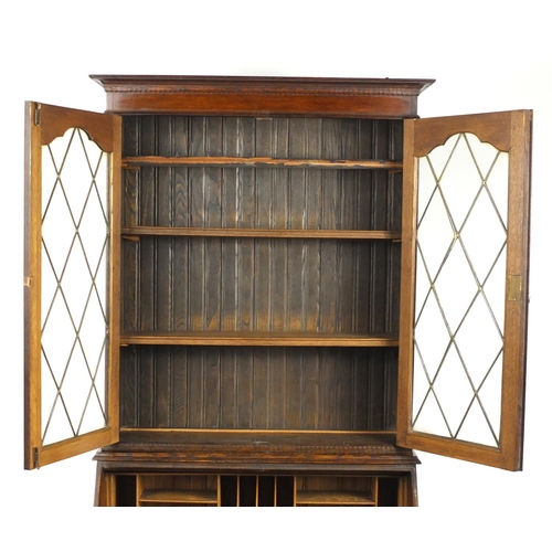 1 - Oak bureau bookcase fitted with a pair of leaded glass doors enclosing three shelves above a fall, w... 
