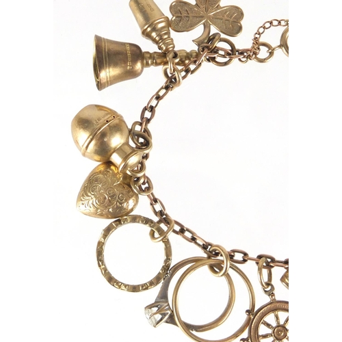 701 - 9ct gold charm bracelet with a selection of mostly gold charms including lion, four leaf clover, shi... 