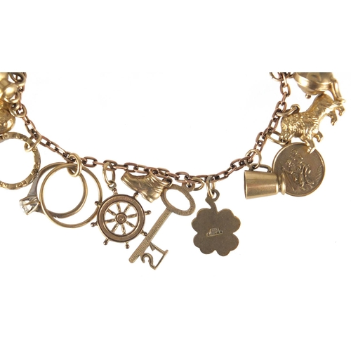 701 - 9ct gold charm bracelet with a selection of mostly gold charms including lion, four leaf clover, shi... 