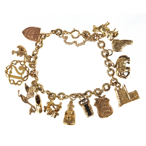 705 - 9ct gold charm bracelet with a selection of mostly gold charms including church, Dutch figure, pixie... 