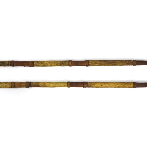 377 - Pair of African tribal hide bound hunting spears, the metal spear heads with incised decoration, eac... 
